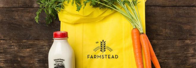 A yellow bag reading "Farmstead" with a bottle of milk to the left and a bunch of carrots to the right.