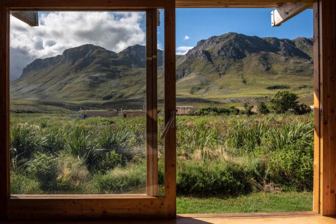 wood-framed sliding glass door opening to mountain views