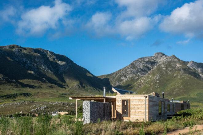 stone and wood cabins with mountains in background