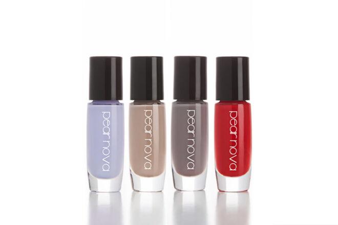 a row of four nail polish bottles in the colors periwinkle, beige, gray and red.