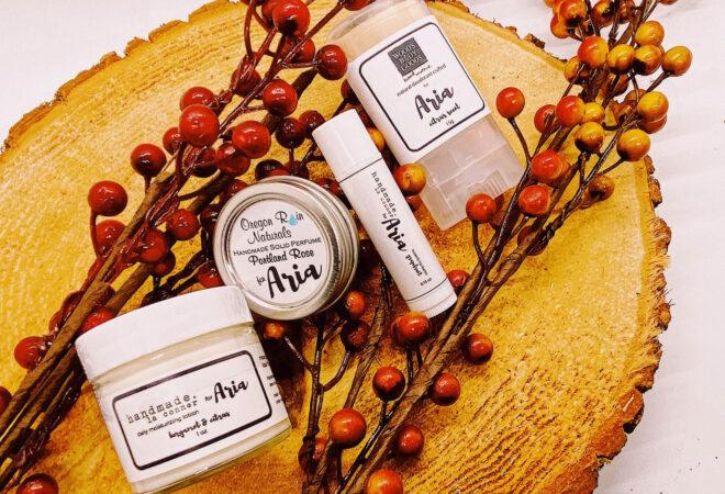 four toiletry products with decorative branches around them.