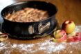 apples near apple cake in pan