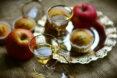 apples, apple muffins and glasses of cider on table