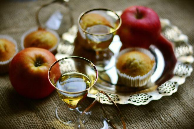 apples, apple muffins and glasses of cider on table