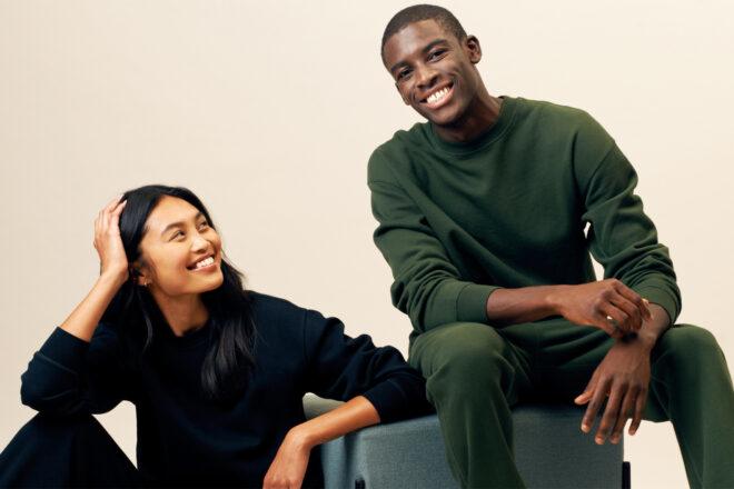 Two people sit next to each other in dark bleu and green loungewear.