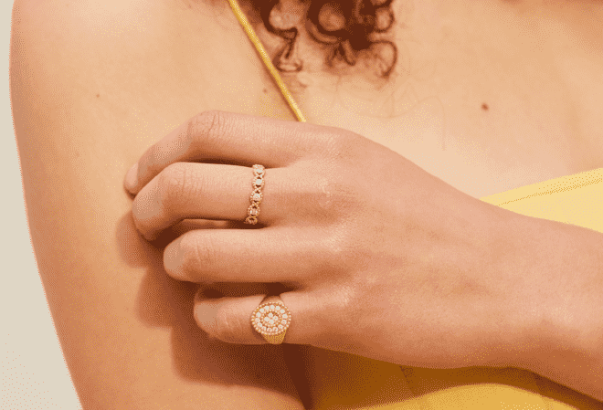 A close-up of a hand wearing two golden rings.