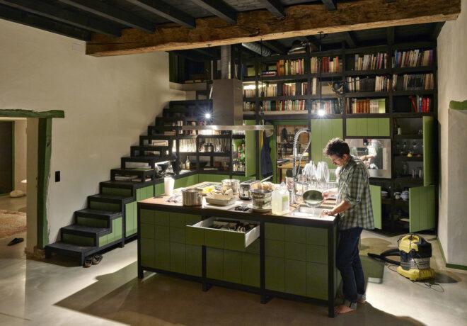 A kitchen with an island with green drawers.