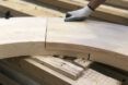 A hand putting together pieces of the wood Circula bench.