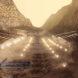 A valley between mountains with lights places all around to light up structures on either side.