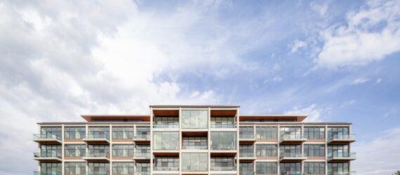large housing complex with walls of glass on each floor