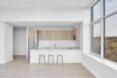bright white apartment with light wood cabinetry in the kitchen