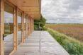 large wood patio next to wood and glass home