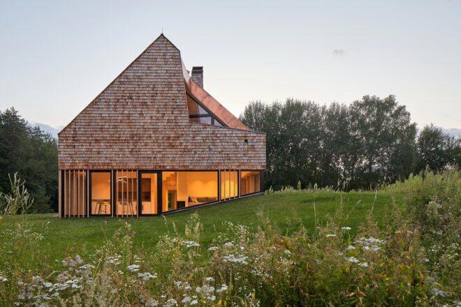 home with bottom floor of glass walls and top floor clad in cedar