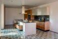 kitchen with patterned floors, white island and wood cabinets