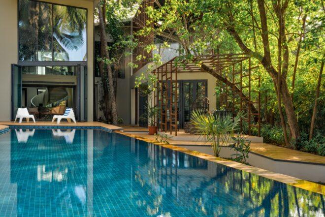 long swimming pool near coconut trees
