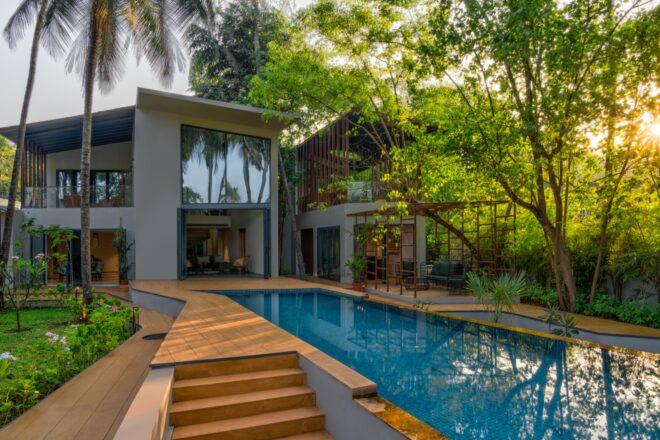 light gray home with large windows near long swimming pool