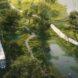 aerial rendering of metro driving on the edge of a park with a lake