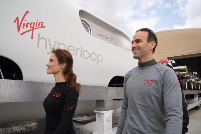 people smiling and walking toward Hyperloop pod