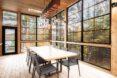 long wood dining table in room with glass walls
