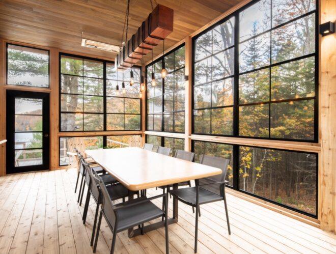 long wood dining table in room with glass walls