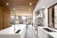 bright white kitchen in room with glass wall and wood ceiling