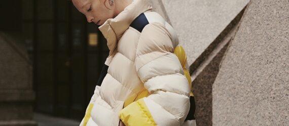 person wearing beige, yellow and navy puffer jacket