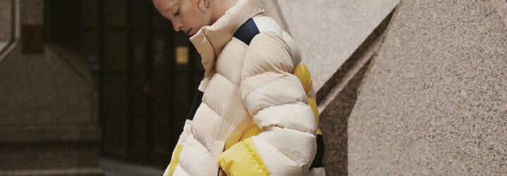 person wearing beige, yellow and navy puffer jacket