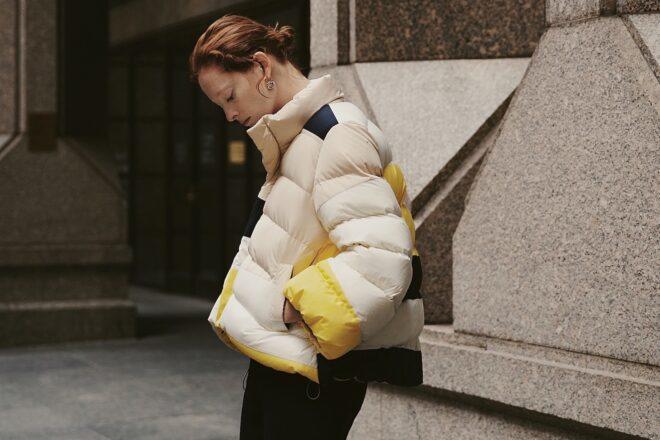 person wearing beige, yellow and navy puffer jacket