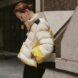 person wearing beige, yellow and navy puffer jacket