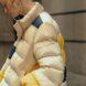 closeup of yellow, beige and navy puffer jacket