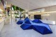 rendering of large, geometric, blue sofa in a modern apartment