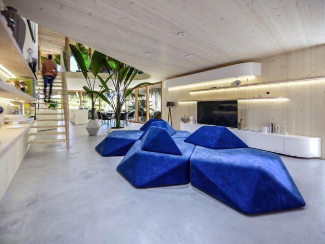 rendering of large, geometric, blue sofa in a modern apartment