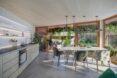 rendering of white dining table across from kitchen with light wood cabinets