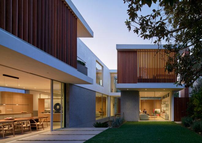 large white home with wood screens over upper windows