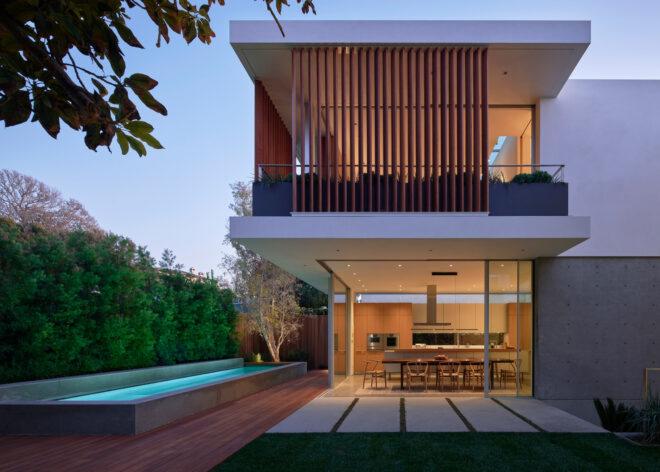 two-story home with wood louvers and a large courtyard