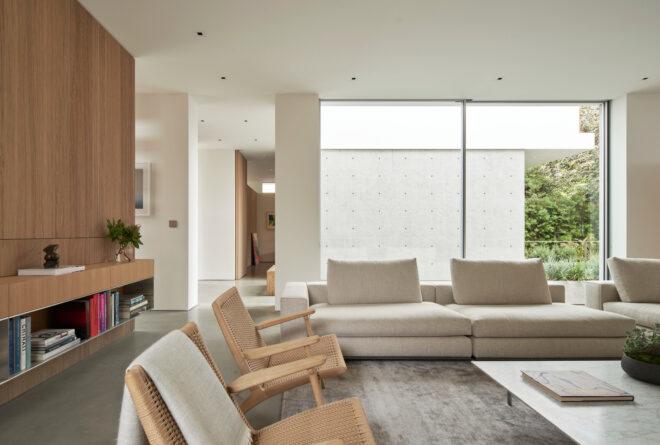 beige furnishings in white living room with large windows