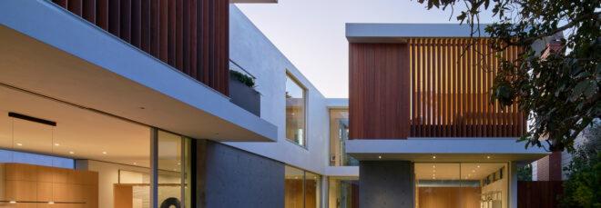 large white home with wood screens over upper windows