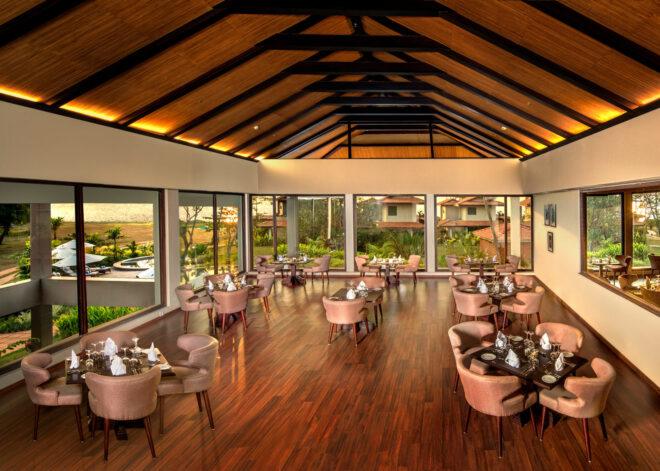 hotel dining area with plush pink chairs and tall, pitched ceiling