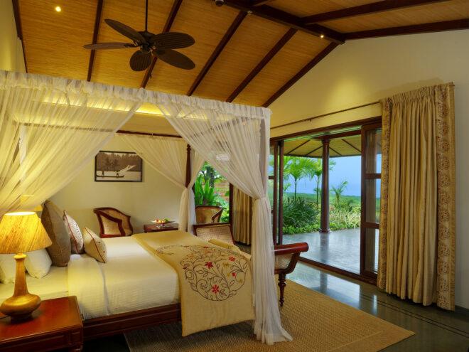 large hotel bed in room with sliding glass wall