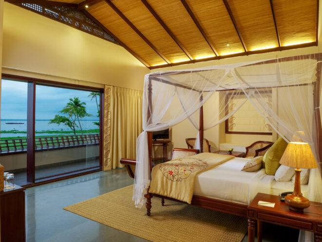 large hotel bed with canopy facing wall of glass
