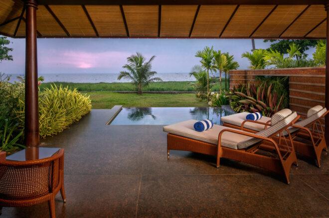 lounge chairs on a deck by a pool at dusk