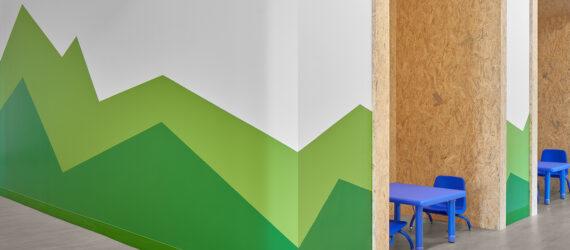 white room with green mountains painted on the wall
