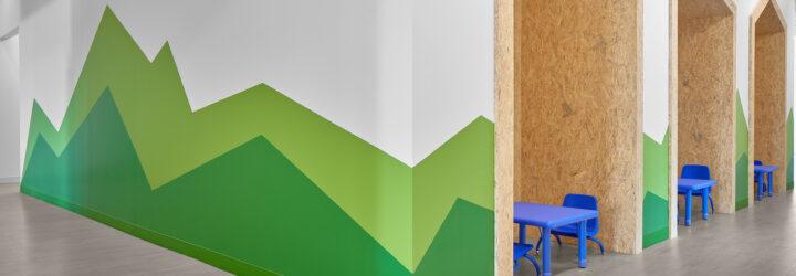 white room with green mountains painted on the wall