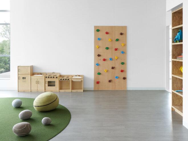 round seats, turf, inbuilt wood bookshelves and a small rock-climbing wall