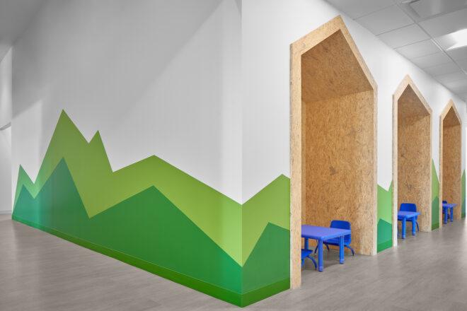 white room with green mountains painted on the wall