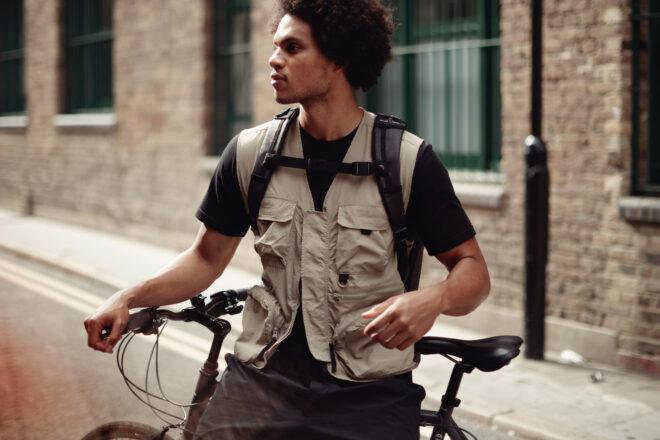 person leaning on bike and wearing a backpack