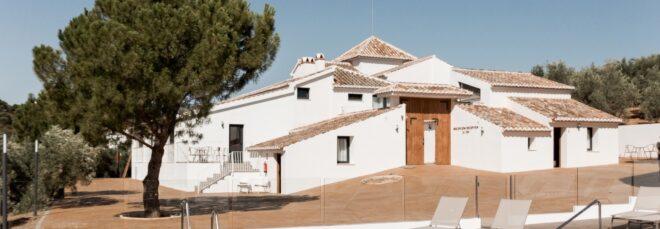 white cortijo building with a pool