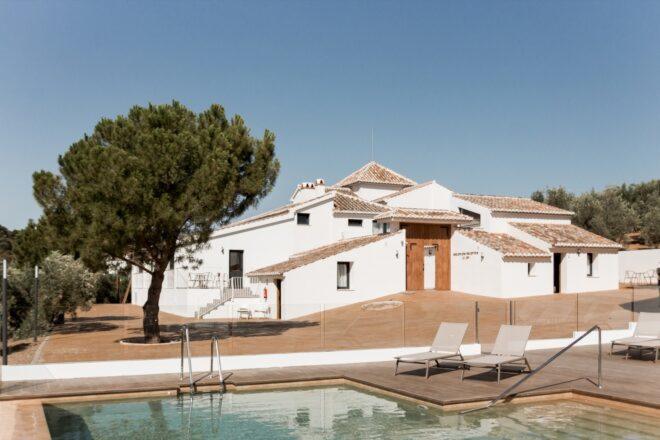 white cortijo building with a pool