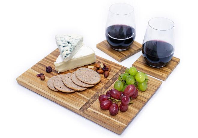 A cheese board accompanied by two glasses of red wine.