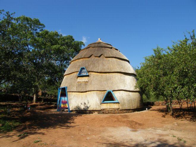 A thatched dome with blue frames for the door and windows.